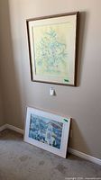 Both framed prints, one leaning, one wall mounted