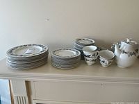 Full set displayed on mantel: plate stacks, cups, saucers, teapot