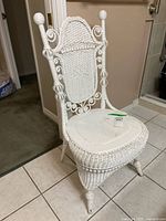 Full view of white wicker vanity chair showing ornate back and legs