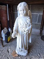 Front view of cement child angel statue with rose bouquet