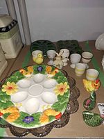 Lot overview showing multicolor platter, egg cups, figurines