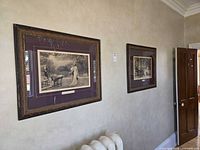 Wall view showing both framed prints with burgundy mats and ornate frames