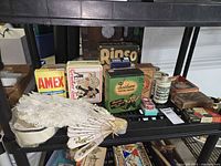 Shelf with assortment of vintage boxes, tins, jars and sailor cap