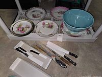 Overall lot showing porcelain plates, turquoise bowl, Henckels knives in boxes, honing steel and pastry brush