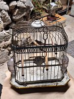 Full view of birdcage showing overall structure, enamel base, glass feeders