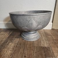 Full view of pewter pedestal punch bowl on floor