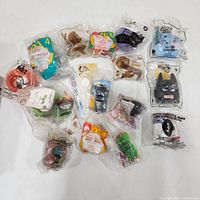 Top view of all sealed Happy Meal toys spread on white surface, showing packaging and labels