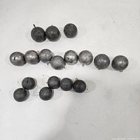 All fifteen lead cannonball sinkers arranged in rows by size