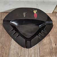 Top view of triangular black resin ashtray with golfer inlay