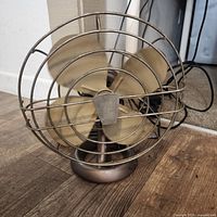 Front view showing four blades, wire cage, round base