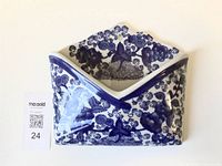 Front view of blue and white ceramic wall pocket with MaxSold scale card