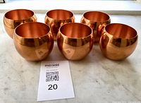 Six copper cups front view