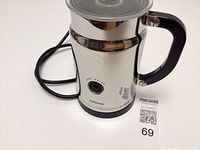 Side view of Nespresso Aeroccino with handle, lid and power cord