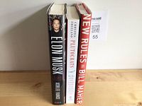 Three upright hardcover books showing spines and top edges