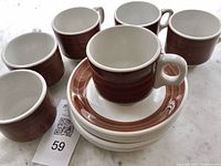 Six cups and saucers grouped on surface