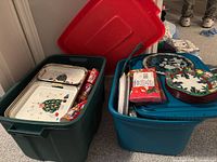 Two totes filled with trays, plates, napkins and mugs visible