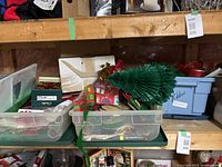 Plastic totes on shelf containing wrapping paper rolls, gift bags, ribbons, boxes and other supplies