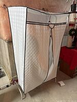 Front view of white metal garment rack with quilted cover