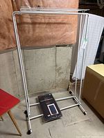 Full view of one rolling rack with packaged garment bag at base