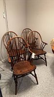 Four matching dark oak Windsor armchairs
