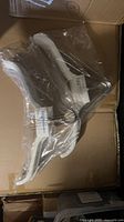 Two unopened packs of Brightroom white velvet hangers inside shipping box