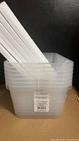 Stack of seven clear storage boxes with lids nested inside