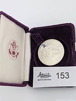 Coin in open presentation case showing interior and U.S. seal