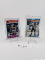 Both Wayne Gretzky cards in hard cases on stands