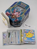 tin, deck box and stack of sleeved cards displayed
