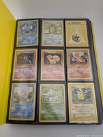 binder page with nine assorted cards including Poliwrath holo, Vulpix, Pikachu and Lightning Energy