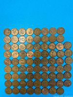Grid layout of roughly 8×10 showing entire group of copper 1-cent coins on blue background