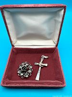 Open red velvet box with two silver pendants