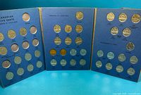 Open tri-fold album showing three panels filled with multiple Canadian five-cent coins
