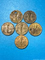 Six 1943 Canadian Tombac 5¢ coins arranged on blue background