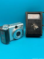 Canon PowerShot A80 camera and Sony pocket AM radio together