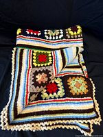 Afghan folded showing granny squares, stripes and scalloped edge