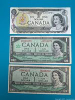 Fronts of all three Canadian $1 banknotes displayed together