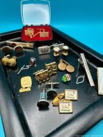 Overview of all cufflinks, tie clips and pins on tray