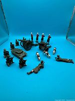 Group shot of tank, two cannons, soldiers and cows