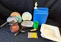 Full lot overview showing cookware, dishware, utensils, water carrier, wash basin