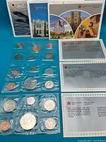 All three sealed coin sets with folders and inserts displayed