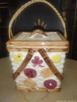 Front view of ceramic cookie jar showing applied cookie decorations and handle