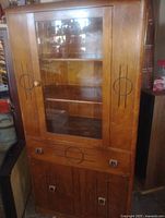 Full front view of the china cupboard showing glass door, shelves, and lower storage doors