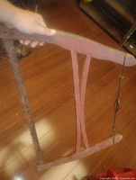 Handheld view of wooden frame buck saw showing blade and tension assembly