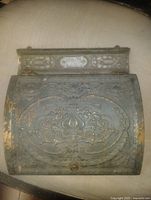 Front view of ornate cast iron mail flap door