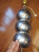 Close-up of three chrome spheres on lamp body