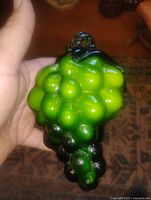 Front view of green glass grape cluster held in hand
