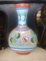 Front view of hand painted terracotta vase showing floral and leaf design