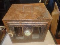 Perspective view showing top handle, rusted exterior and glass windows