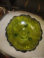 Top view of olive green glass bowl showing scalloped rim and interior sunburst pattern